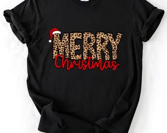 May include: A black short-sleeved t-shirt featuring the text MERRY in a brown and black leopard print pattern with a red Santa hat on the letter M, and the word Christmas in red cursive script lettering centered below the leopard print.
