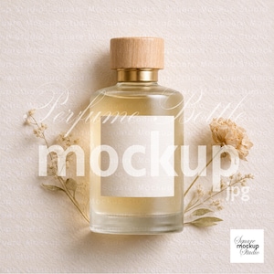 May include: A clear glass perfume bottle containing a light-coloured liquid, topped with a cylindrical wooden cap. The bottle has a blank, rectangular white label on the front. Two delicate, dried beige floral stems are placed on either side of the bottle.