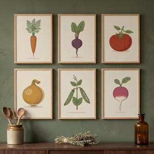 Peut inclure: Un ensemble de six cadres muraux présentant des illustrations d'une carotte, d'une betterave, d'une tomate, d'un oignon, d'une gousse de pois et d'un radis. Chaque impression est encadrée de bois clair sur un fond crème.