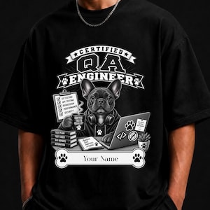 Puede incluir: Una camiseta negra con un gráfico de un bulldog francés con auriculares trabajando en un portátil. El texto dice CERTIFIED QA ENGINEER y Your Name. El diseño incluye un portapapeles con categorías de prueba, libros y una taza de café.