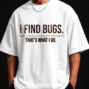 Puede incluir: Una camiseta blanca de manga corta con el texto I FIND BUGS. THAT'S WHAT I DO. en un patrón moteado marrón y negro. La prenda tiene cuello redondo, un corte holgado y una línea discontinua que separa las dos líneas de texto en el frente.