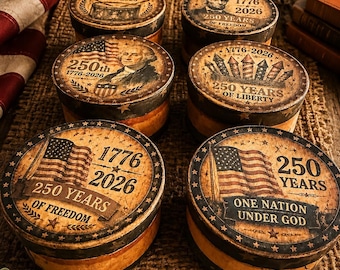 Può includere: Sei scatole rotonde color marrone chiaro con coperchi caratterizzati da disegni patriottici. I coperchi riportano testi come 1776-2026, 250 Years of Freedom, 250 Years of Liberty e One Nation Under God, insieme a illustrazioni della bandiera americana, fuochi d'artificio e figure storiche.