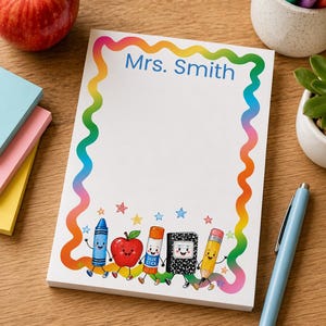 May include: A rectangular notepad with a rainbow-colored wavy border and the text Mrs. Smith printed at the top. The bottom features a colorful illustration of a cartoon crayon, apple, glue stick, notebook, and pencil holding hands with small stars.