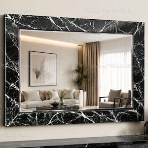 May include: A rectangular wall mirror featuring a wide frame with a black marble finish and prominent white veining. The reflective glass surface displays a clear view of a living room interior, including a sofa, a coffee table, and curtains.