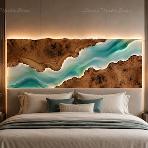 May include: A rectangular wall art piece featuring a natural live-edge wood slab with a central, flowing river-like inlay of translucent turquoise and white resin. The artwork is backlit, creating a glowing effect along the edges of the wood.