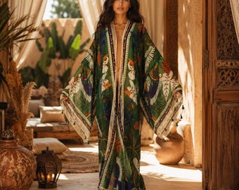 May include: A floor-length open-front kimono robe featuring a vibrant green base with a tropical botanical print of large leaves and colorful birds. The garment has wide, flowing sleeves and a cream-colored trim along the front edges.