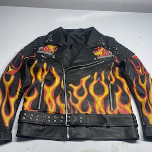 May include: A black leather motorcycle jacket featuring a vibrant yellow, orange, and red flame pattern across the front and sleeves. The jacket includes silver-toned metal zippers, a buckled waist belt, and silver studs on the shoulders.
