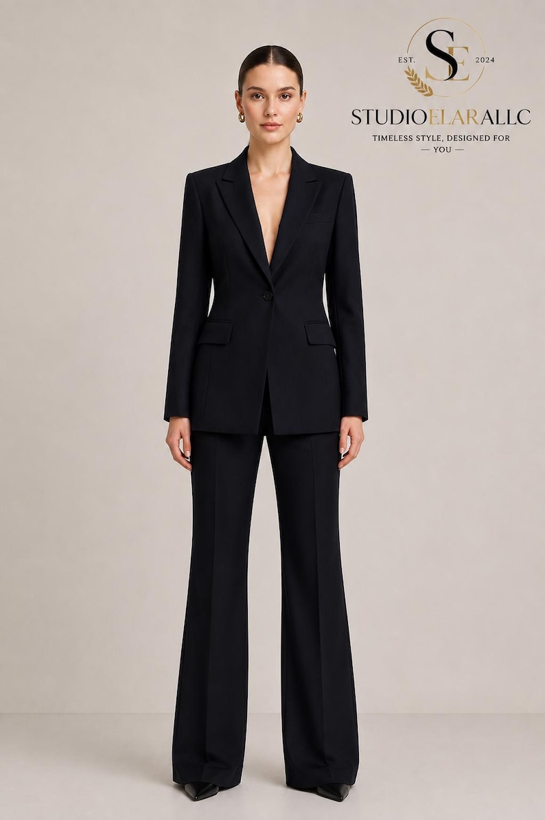 May include: A black tailored suit consisting of a single-button blazer with notched lapels and flap pockets, paired with matching wide-leg trousers. The logo in the top right corner reads STUDIOELARALLC EST. 2024 TIMELESS STYLE, DESIGNED FOR YOU.