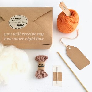 May include: A craft kit with a brown box, orange yarn, and a ball of white fluff. The box has a sticker that says "Little Conkers...make great things" and the text "you will receive my new more rigid box". Includes a tag that says "crochet time!"