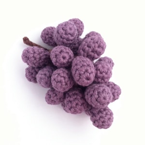 A realistic crocheted bunch of red grapes.