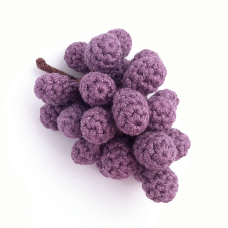 A realistic crocheted bunch of red grapes.