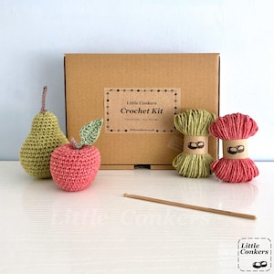 May include: A crochet kit in a brown cardboard box labeled Little Conkers Crochet Kit. Included are a crocheted green pear, a red apple with a green leaf, two skeins of yarn in green and red with paper bands, and a wooden crochet hook.