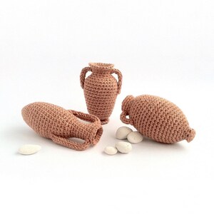 Miniature crocheted amphorae in three different styles.