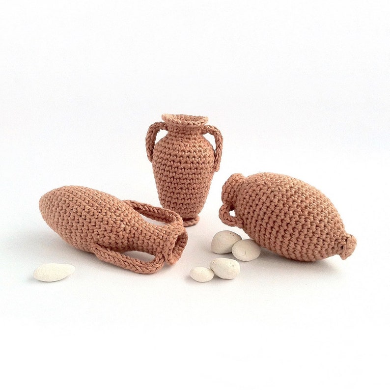 Miniature crocheted amphorae in three different styles.