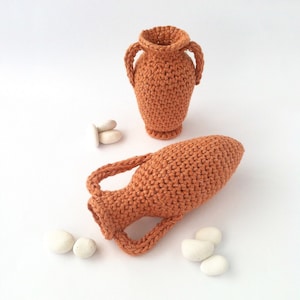 Miniature crocheted amphorae of two different styles.