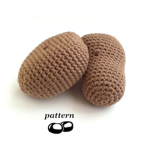 Puede incluir: Dos objetos ovalados marrones de ganchillo. Los objetos están hechos de hilo texturizado y parecen hechos a mano. La palabra "pattern" está impresa en negro, junto con un gráfico de dos objetos negros.