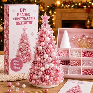 Könnte beinhalten: Ein DIY-Bastelset für einen Weihnachtsbaum aus Perlen mit einer Schachtel, die den Text DIY BEADED CHRISTMAS TREE CRAFT KIT trägt, einem fertigen rosa-weißen Perlenbaum mit Sternspitze, einem Fach mit Perlen, Stiften, einem Kegel und Anleitung.