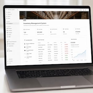 Op de afbeelding: Een laptopscherm met een dashboard voor een voorraadbeheersysteem. De interface bevat een navigatiebalk aan de zijkant, een koptekst met een afbeelding van een magazijn en datakaarten met product-, verkoop- en voorraadgegevens.