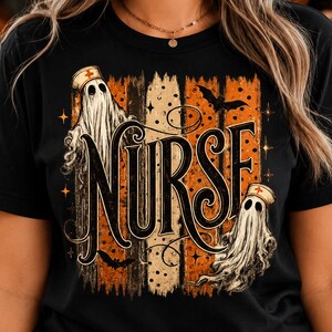 May include: A black t-shirt featuring a graphic design with the word NURSE in large black lettering. The design includes two white ghosts wearing nurse caps with red crosses, orange and black vertical stripes, bats, and small stars.