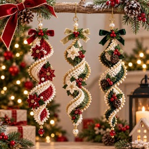 May include: Three spiral-shaped Christmas ornaments hanging from a branch. Each features crocheted fabric in red, cream, or green, accented with small white pearls, red berries, pinecones, and fabric bows at the top, finished with a dangling bead.