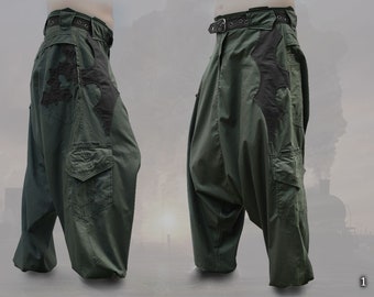 May include: Green cargo pants with a black fabric design on the front and side. The pants have a wide leg and a loose fit.