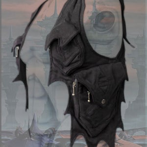 May include: Black leather shoulder bag with multiple pockets and a jagged, pointed design. The bag has a zipper closure and silver hardware.