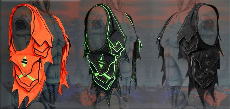 May include: Three vests with a unique, futuristic design. The vests are made of black, green, and orange fabric with contrasting black trim. Each vest has multiple pockets and a jagged, wing-like design.