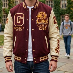 以下が含まれることがあります： 大きな文字G、ライオンのエンブレム、G University Est. 1958およびLions Class of 2024の文字が入った、マルーンとクリーム色のバーシティジャケット。袖はクリーム色で、小さなアメリカ国旗のパッチ、数字の24、星、Lionsの文字があしらわれています。