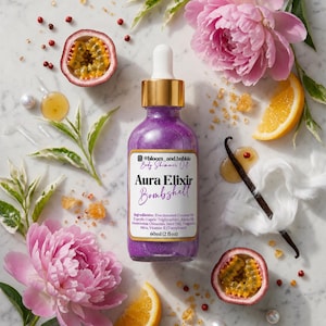 May include: A 60ml (2 fl oz) glass bottle of purple body shimmer oil labeled Aura Elixir Bombshell with a gold dropper cap. The label lists ingredients including fractionated coconut oil, jojoba oil, mica, and vitamin E, plus the handle @bloom_and_bubble.