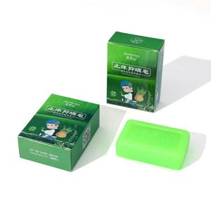 May include: Two rectangular green cardboard boxes and one solid light green rectangular bar of soap. The boxes feature the brand name SIMISI, Chinese text, and an illustration of a person carrying a basket of herbs. The soap has a smooth surface.