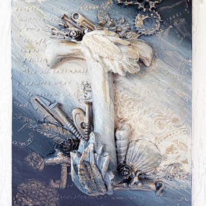 May include: A rectangular mixed media wall art piece featuring a central cross shape adorned with metallic gears, screws, feathers, and seashells. The background is a gradient of dark blue to white with embossed script text and floral patterns.