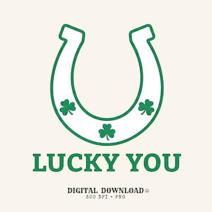 Op de afbeelding: Een witte hoefijzergrafiek met een groene omlijning en drie groene klavertjes op het oppervlak. Onder het hoefijzer staat de tekst LUCKY YOU in groene hoofdletters, gevolgd door de tekst DIGITAL DOWNLOAD 300 DPI + PNG.