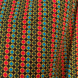 May include: A fabric featuring a repeating geometric pattern of vertical columns. Each column contains alternating diamond shapes in red, blue, and dark green, all outlined in yellow and set against a solid black background.