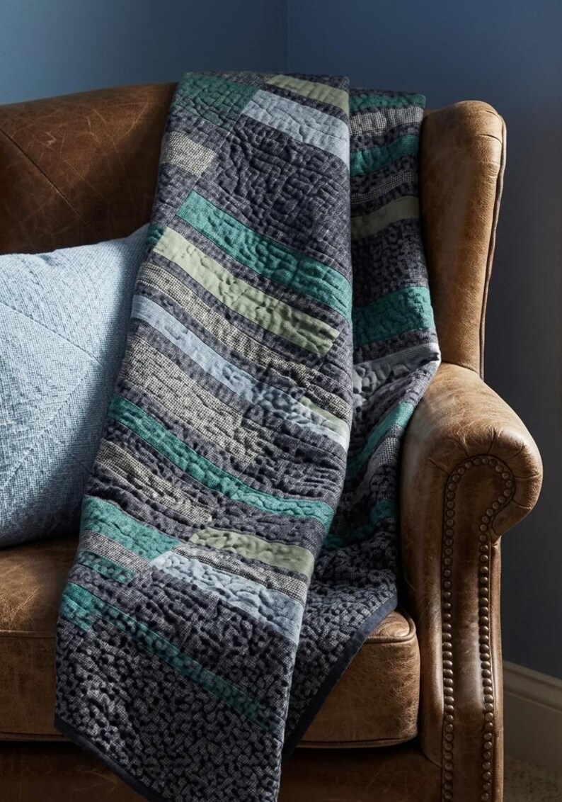Close-up texture of hand-quilted stipple stitching on modern patchwork quilt