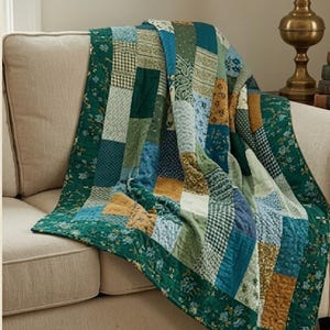 Puede incluir: Una colcha de patchwork que presenta una variedad de paneles de tela rectangulares en tonos verde oscuro, salvia, azul claro y amarillo mostaza. La colcha muestra diversos patrones, incluyendo estampados florales, cuadros vichy y diseños paisley.