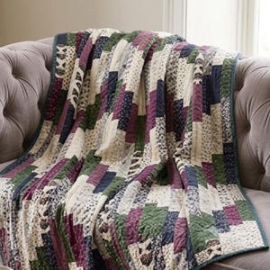 May include: A patchwork quilt featuring a repeating pattern of rectangular fabric strips in shades of deep purple, forest green, navy blue, and cream. The quilt displays various small-scale floral and geometric prints with visible stitching.