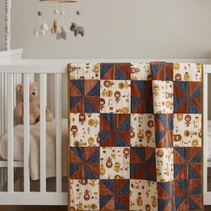 May include: A patchwork quilt featuring alternating squares of cream fabric with a repeating pattern of cartoon jungle animals and solid squares of navy blue and rust orange fabric arranged in a pinwheel design with a mustard yellow border.