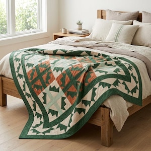 May include: A quilt featuring a geometric pattern in shades of dark green, light green, and burnt orange, draped over a wooden bed frame. The bedding includes a light beige duvet cover and matching pillows with a subtle green stripe detail.