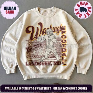 May include: A sand-coloured crewneck sweatshirt featuring a maroon and gold graphic of a football player in a stadium. The text reads Washington Football, Est. 1932, and Landover, MD. The design includes a vintage-style illustration of a player.