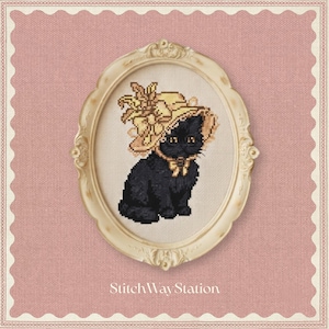 May include: A cross-stitch embroidery of a black cat wearing a yellow bonnet with a bow, framed in an oval cream-coloured frame. The text StitchWayStation is printed in white at the bottom. The entire design is set against a pink textured background.