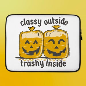 May include: A white laptop sleeve featuring a graphic of two yellow, rectangular bread-like shapes with jack-o'-lantern faces. The text "classy outside" appears above the shapes, and "trashy inside" is printed below in dark gray lettering.
