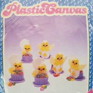 May include: A plastic canvas craft kit featuring six baby chick egg cups. The kit includes instructions and materials to create the cups, which are approximately 2 1/2 inches by 4 1/2 inches each. The kit is designed by Elizabeth O.