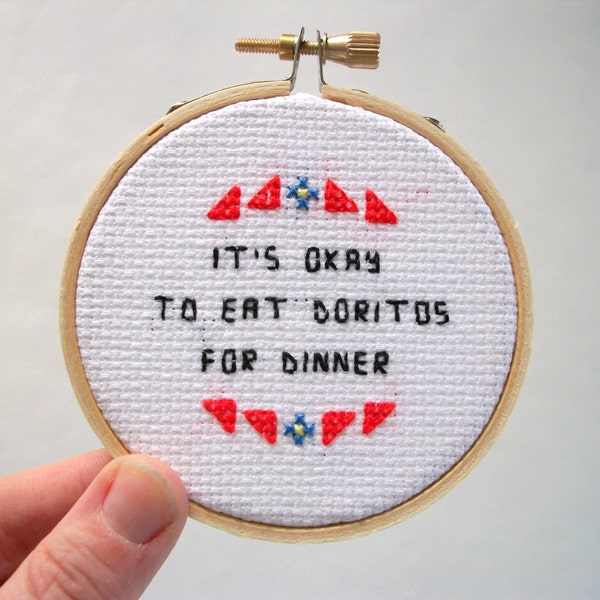 It's okay to eat chips for dinner cross stitch -- tiny orange triangles and saying, completed mini cross stitch from the "It's Okay" series