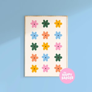 May include: A rectangular wall art print featuring a grid of fifteen stylised flowers in pink, dark green, yellow, light blue, and orange on a cream background. A pink circular logo in the bottom right corner displays the text THE HAPPY BADGER.