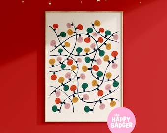 May include: A framed rectangular wall art print featuring a pattern of tangled dark blue electrical cords with multi-colored light bulbs in red, green, yellow, and pink against a cream background with small dots. A pink circular logo reads the happy badger.
