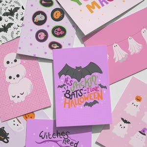 Pode incluir: Uma cole&ccedil;&atilde;o de cart&otilde;es de felicita&ccedil;&otilde;es retangulares com temas de Halloween. Os designs incluem uma pilha de tr&ecirc;s cr&acirc;nios, fantasmas num estendal, ab&oacute;boras, morcegos e o texto It's frickin' BATS I love HALLOWEEN e Witches need.