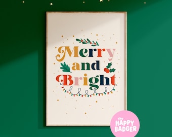 May include: A rectangular wall print featuring the text Merry and Bright in colorful retro typography. The design includes illustrations of holly leaves, red berries, and a string of Christmas lights on a cream background, framed in light wood.