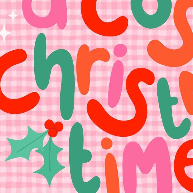 May include: A graphic print featuring the text a cozy christmas time in rounded, colorful letters of red, pink, orange, and green. The background is a light pink gingham pattern with small white star accents and a green holly leaf illustration.