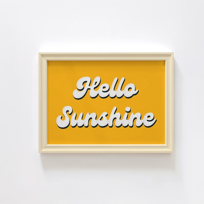 May include: A framed print with a yellow background and white text that reads "Hello Sunshine".