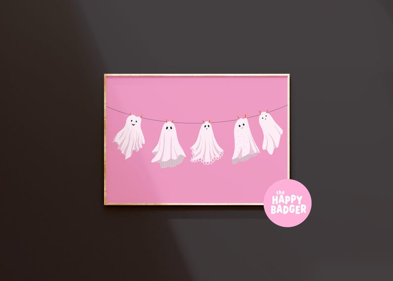 Pode incluir: Uma impress&atilde;o de arte retangular com cinco fantasmas brancos pendurados num estendal contra um fundo rosa s&oacute;lido. Cada fantasma tem um rosto simples e uma bainha &uacute;nica. Um log&oacute;tipo circular rosa apresenta o texto the happy badger em branco.